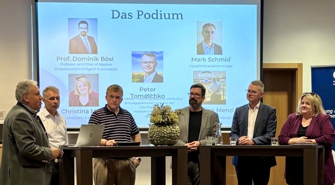Sechs Teilnehmende bei einer Podiumsdiskussion zu Social-Media-Regulierung; im Hintergrund die Präsentationsfolie „Das Podium“.